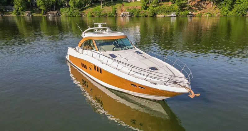  Yacht Photos Pics 2006 Sea Ray 60 Sundancer yacht on calm water, surrounded by lush greenery.