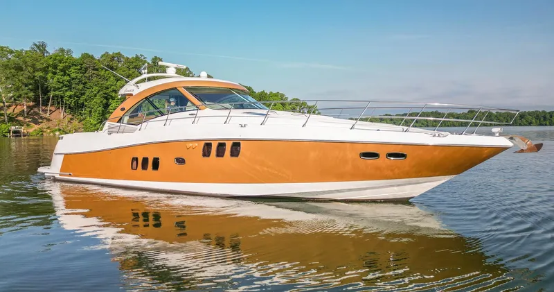  Yacht Photos Pics 2006 Sea Ray 60 Sundancer yacht on calm water, surrounded by lush greenery.