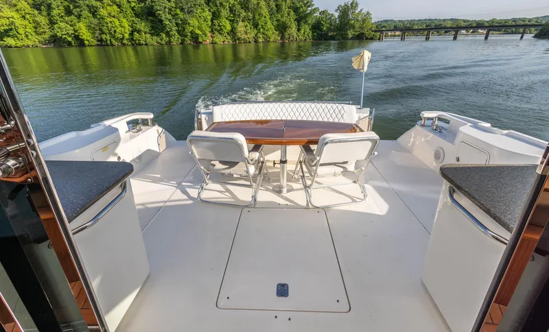  Yacht Photos Pics 2006 Sea Ray 60 Sundancer yacht deck with seating, table, and scenic river view.