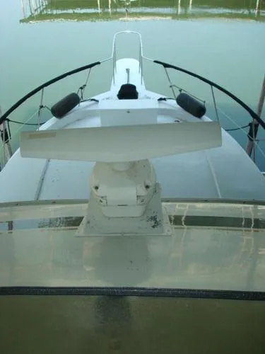  Yacht Photos Pics 1988 Chris-Craft Constellation boat deck with radar, docked on calm water.