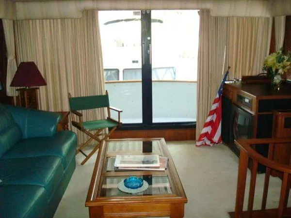  Yacht Photos Pics Interior of 1988 Chris-Craft Constellation yacht with seating, table, and American flag.
