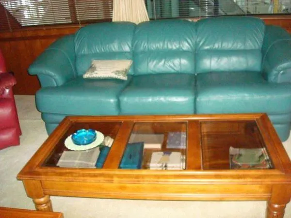  Yacht Photos Pics Teal leather sofa and wooden coffee table inside 1988 Chris-Craft Constellation yacht.