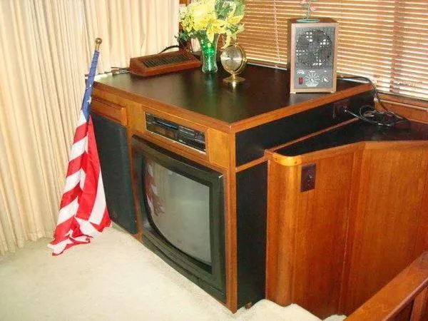  Yacht Photos Pics 1988 Chris-Craft Constellation interior with vintage TV, American flag, and decor elements.