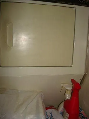  Yacht Photos Pics 1988 Chris-Craft Constellation interior with cleaning supplies and storage compartment.