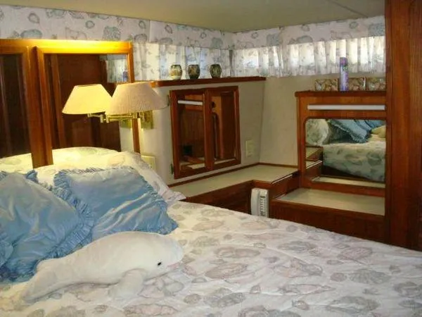  Yacht Photos Pics Luxurious 1988 Chris-Craft Constellation yacht bedroom with plush bedding and elegant wood accents.