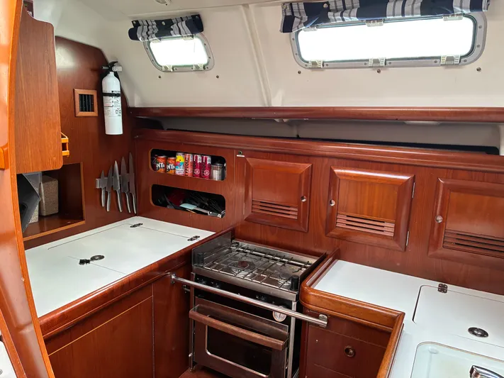 Danae Yacht Photos Pics Galley of 2003 Beneteau Oceanis Clipper 393 with stove, storage, and wooden cabinetry.