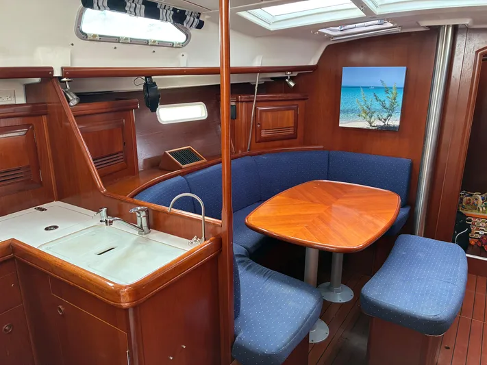Danae Yacht Photos Pics Interior of 2003 Beneteau Oceanis Clipper 393 yacht with wooden dining area and kitchenette.