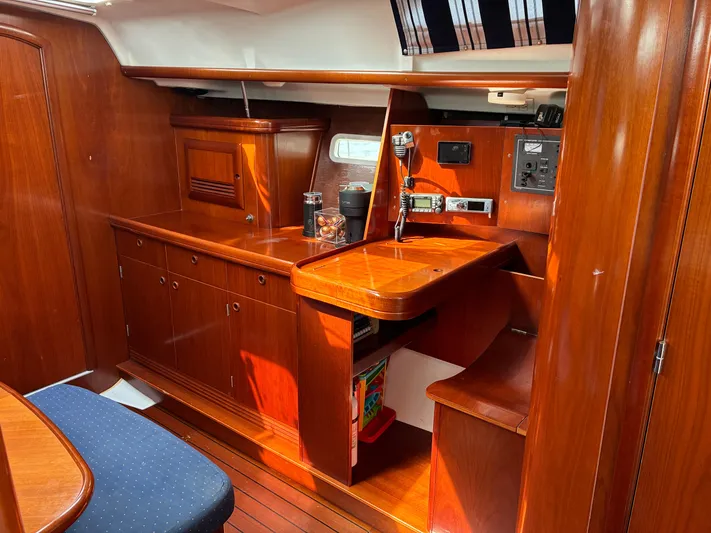 Danae Yacht Photos Pics Interior of 2003 Beneteau Oceanis Clipper 393 with polished wood cabinetry and navigation station.