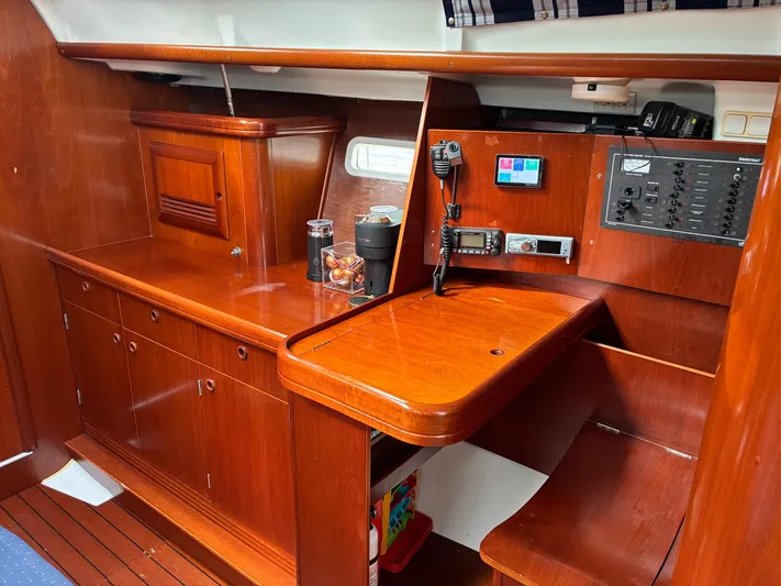 Danae Yacht Photos Pics Interior of 2003 Beneteau Oceanis Clipper 393 yacht with wooden cabinetry and navigation equipment.