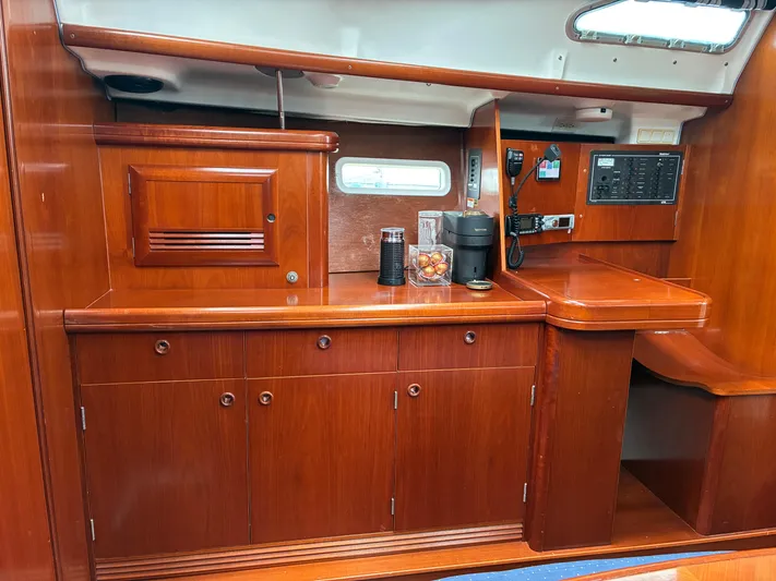 Danae Yacht Photos Pics Interior of 2003 Beneteau Oceanis Clipper 393 yacht with wooden cabinetry and navigation equipment.