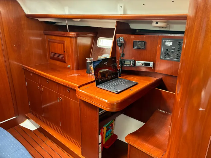 Danae Yacht Photos Pics Navigation station inside 2003 Beneteau Oceanis Clipper 393 yacht with wooden cabinetry and electronics.