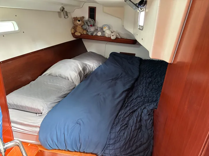 Danae Yacht Photos Pics Cozy cabin interior of 2003 Beneteau Oceanis Clipper 393 with plush bedding and stuffed animals.
