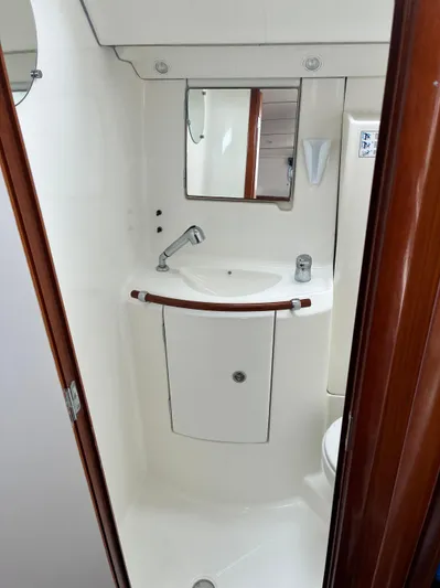 Danae Yacht Photos Pics Compact bathroom in a 2003 Beneteau Oceanis Clipper 393 yacht, featuring a sink and mirror.