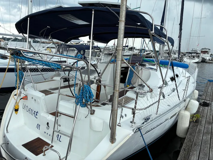 Danae Yacht Photos Pics 2003 Beneteau Oceanis Clipper 393 yacht docked at marina, featuring blue canopy and white hull.