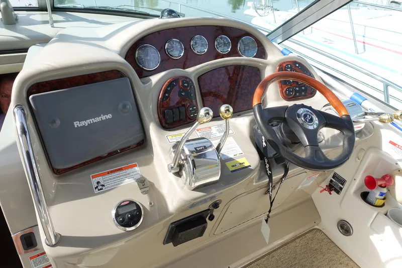 Yacht Photos Pics 2007 Sea Ray 320 Sundancer helm with Raymarine navigation system and wood-accented steering wheel.