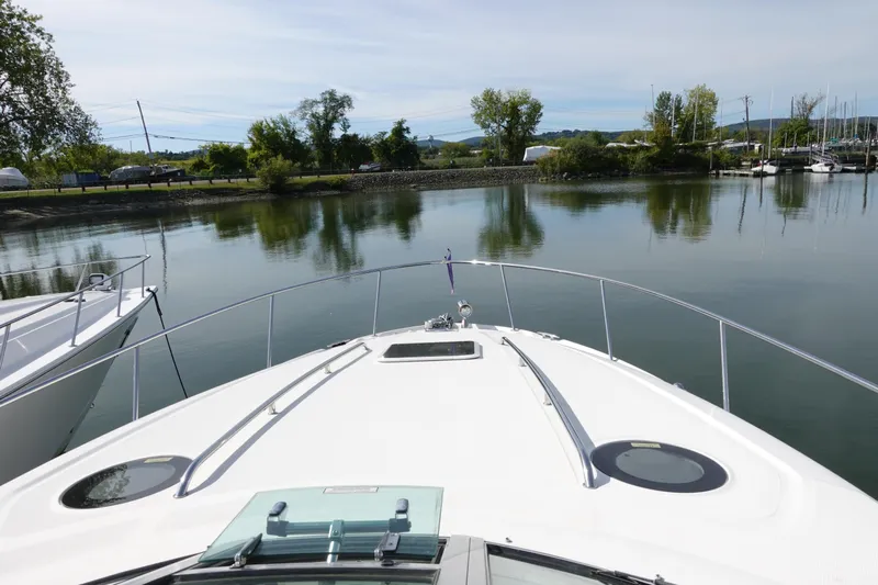  Yacht Photos Pics 2007 Sea Ray 320 Sundancer cruising on a calm lake with scenic shoreline views.