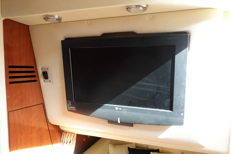  Yacht Photos Pics LG TV inside 2007 Sea Ray 320 Sundancer yacht cabin, featuring wood paneling.