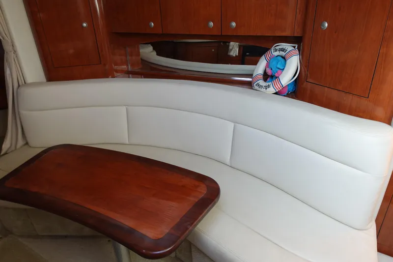  Yacht Photos Pics Luxurious interior of 2007 Sea Ray 320 Sundancer with white seating and wooden table.