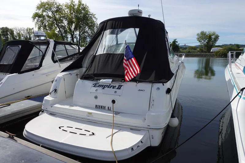  Yacht Photos Pics 2007 Sea Ray 320 Sundancer docked with American flag, rear view.