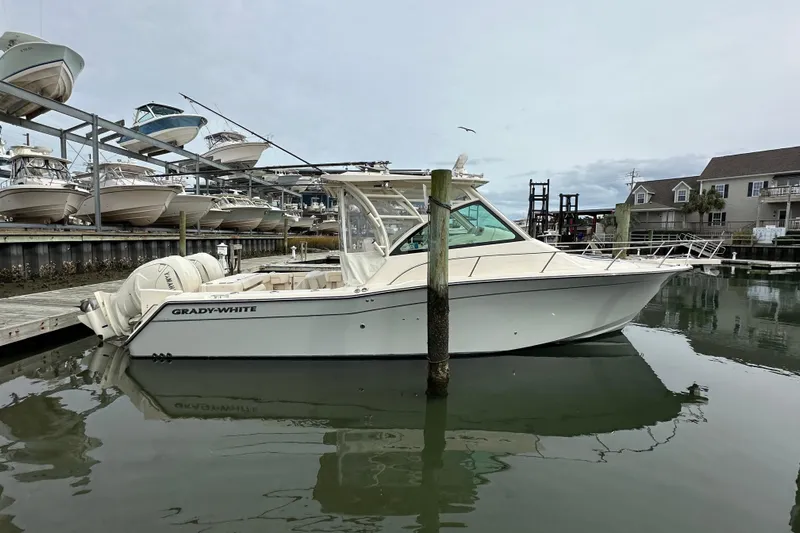  Yacht Photos Pics 2024 Grady-White Express 330 boat docked in a marina, surrounded by other vessels.