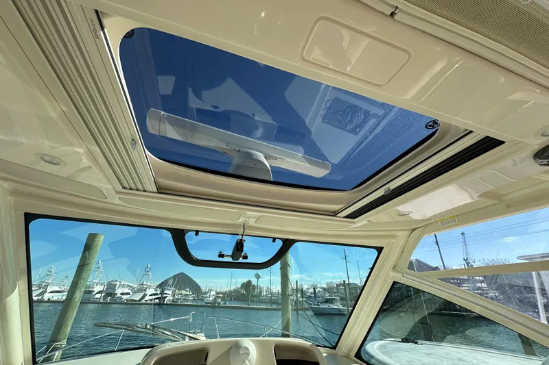  Yacht Photos Pics Interior view of 2024 Grady-White Express 330 boat with sunroof and marina background.