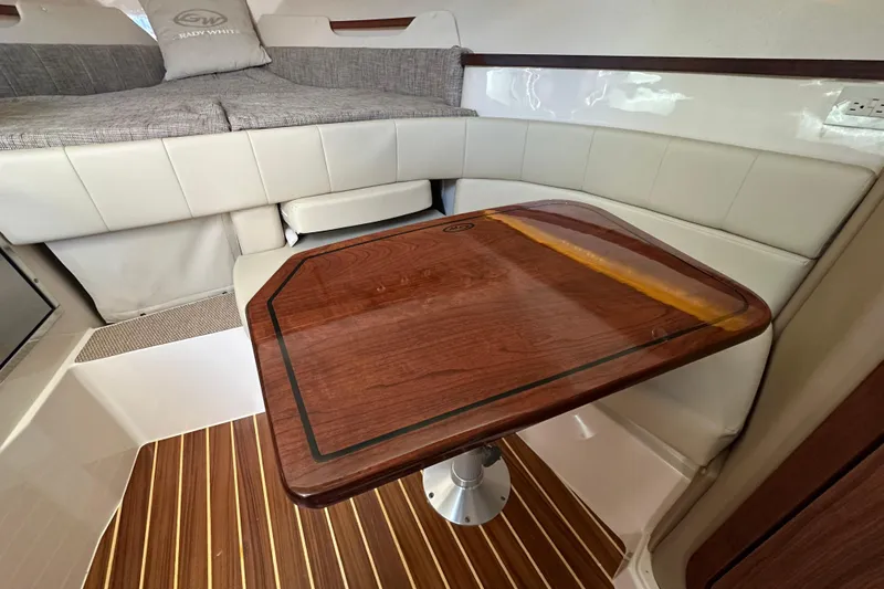  Yacht Photos Pics 2024 Grady-White Express 330 cabin interior with wooden table and cushioned seating.