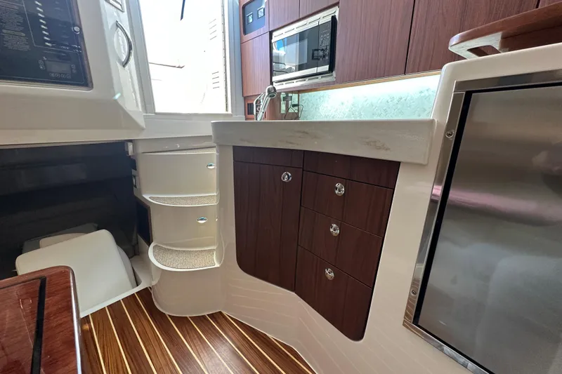  Yacht Photos Pics 2024 Grady-White Express 330 interior with kitchenette, wood cabinets, and modern appliances.