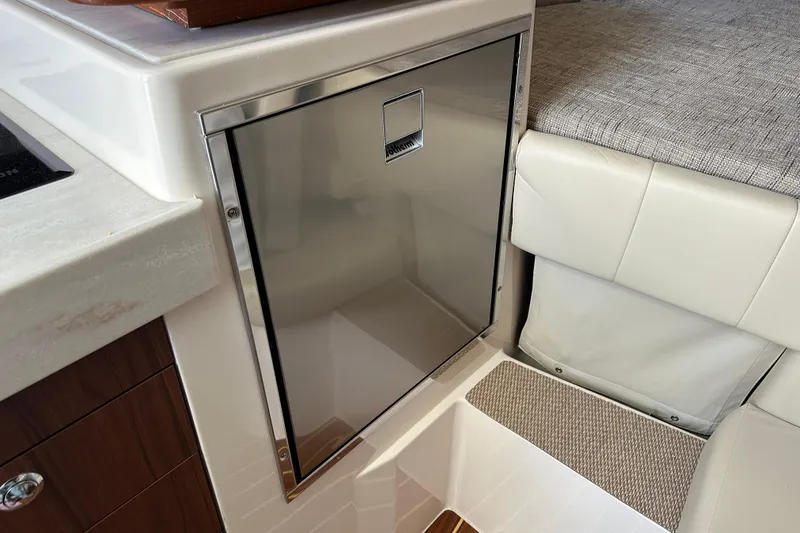  Yacht Photos Pics 2024 Grady-White Express 330 interior with stainless steel fridge and cushioned seating.