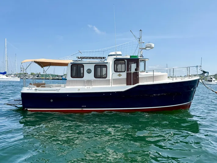 Sam Mcgee Yacht Photos Pics 2009 Ranger Tugs R-29 boat on water, featuring a blue hull and tan canopy.
