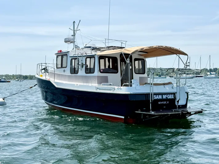 Sam Mcgee Yacht Photos Pics 2009 Ranger Tugs R-29 boat on water, featuring a canopy and moored in a scenic harbor.