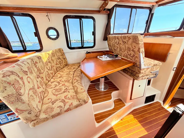 Sam Mcgee Yacht Photos Pics Interior of 2009 Ranger Tugs R-29 with patterned seating and wooden table.