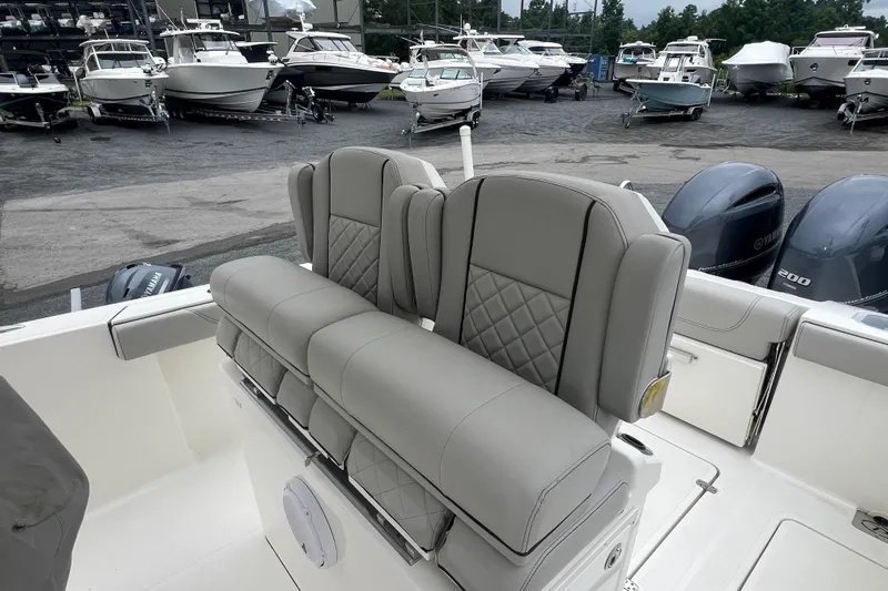 Happy Hours Yacht Photos Pics 2023 Pursuit S 268 Sport boat with luxurious seating, docked among other boats.