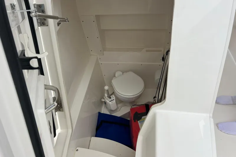 Happy Hours Yacht Photos Pics 2023 Pursuit S 268 Sport boat interior with compact marine toilet.