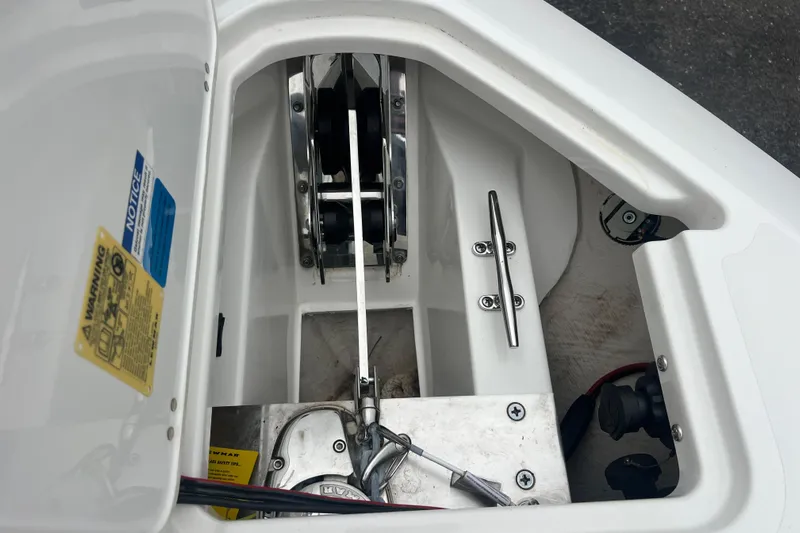 Happy Hours Yacht Photos Pics 2023 Pursuit S 268 Sport boat anchor compartment with cleat and warning labels.