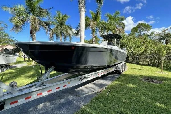  Yacht Photos Pics 1996 Formula 382 SR1 boat on trailer, surrounded by palm trees and greenery.