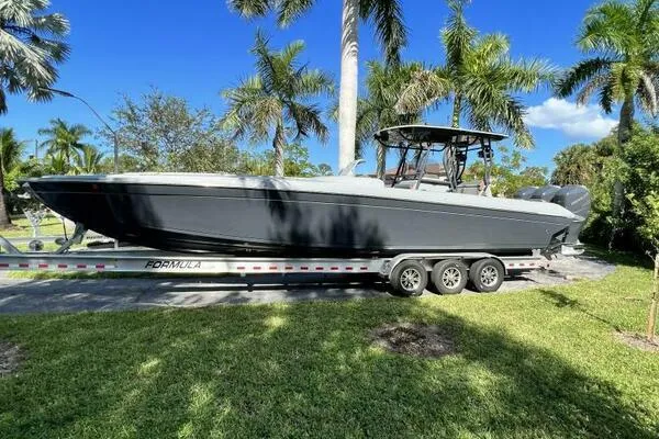  Yacht Photos Pics 1996 Formula 382 SR1 boat on trailer, surrounded by palm trees and clear blue sky.