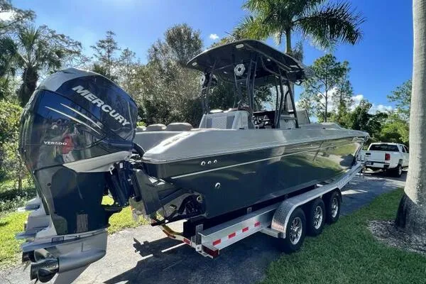  Yacht Photos Pics 1996 Formula 382 SR1 boat on trailer with Mercury engine, surrounded by trees.