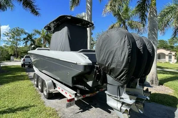  Yacht Photos Pics 1996 Formula 382 SR1 boat on trailer with covered engines, parked near palm trees.