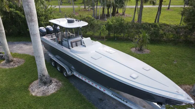  Yacht Photos Pics 1996 Formula 382 SR1 boat on trailer, parked outdoors near palm trees.