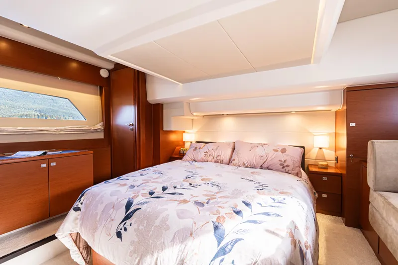 Luna Maris Yacht Photos Pics Luxurious bedroom interior of 2016 Prestige 550 Flybridge yacht with elegant bedding and warm lighting.
