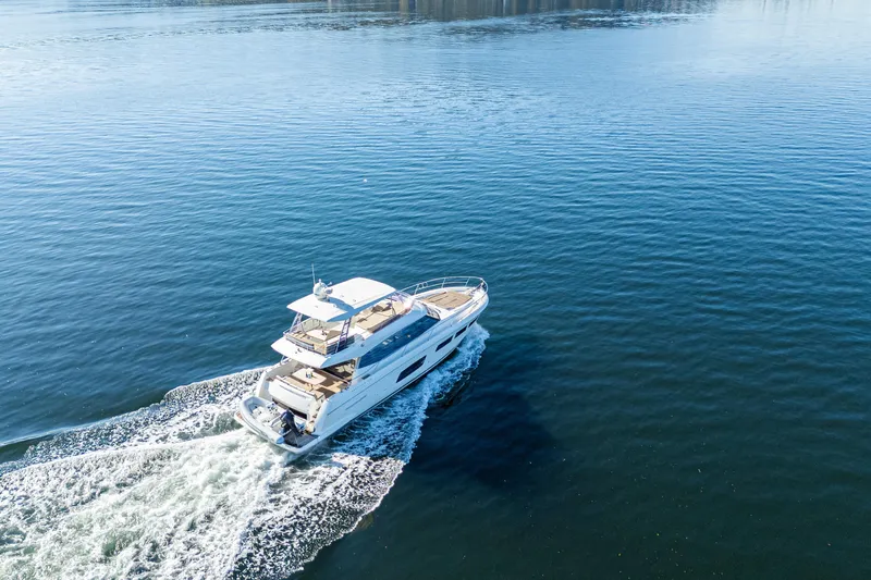 Luna Maris Yacht Photos Pics Aerial view of 2016 Prestige 550 Flybridge yacht cruising on open water.