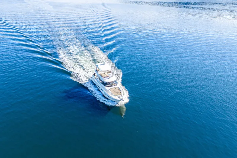 Luna Maris Yacht Photos Pics Aerial view of 2016 Prestige 550 Flybridge yacht cruising on open blue water.