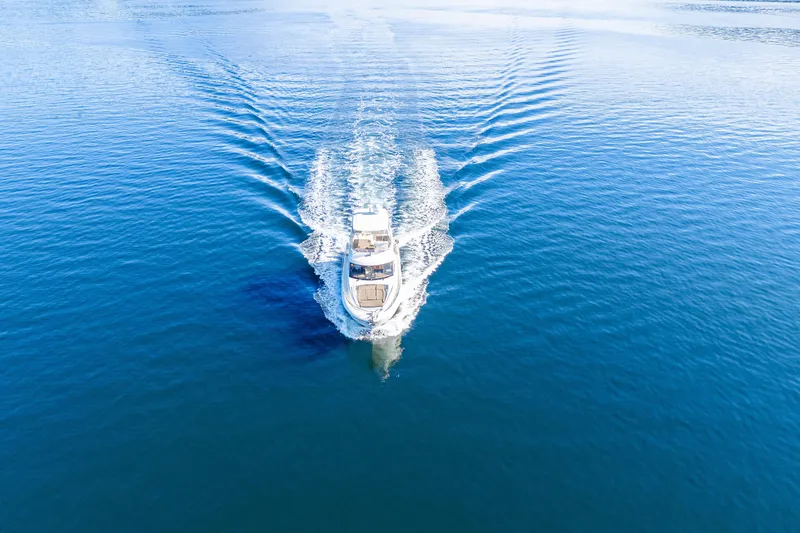 Luna Maris Yacht Photos Pics Aerial view of 2016 Prestige 550 Flybridge yacht cruising on calm blue waters.