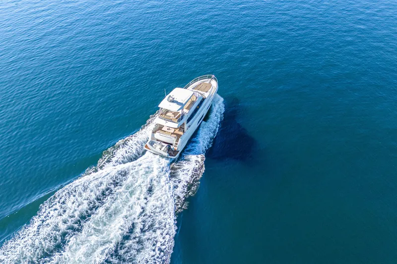 Luna Maris Yacht Photos Pics Aerial view of 2016 Prestige 550 Flybridge yacht cruising on open water.
