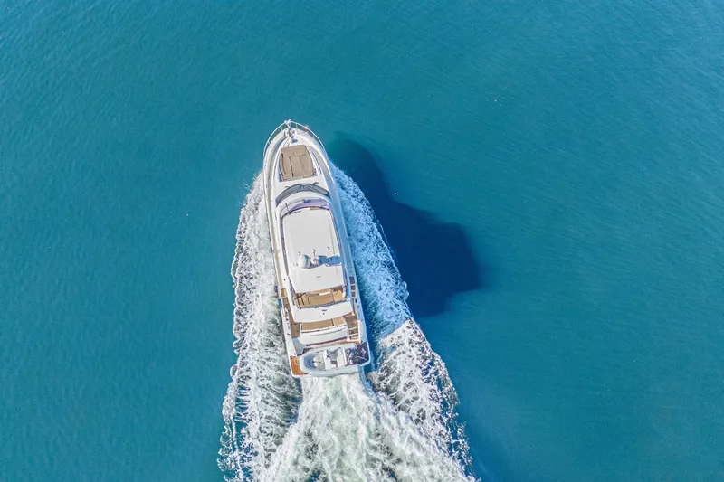 Luna Maris Yacht Photos Pics Aerial view of 2016 Prestige 550 Flybridge yacht cruising on blue water.