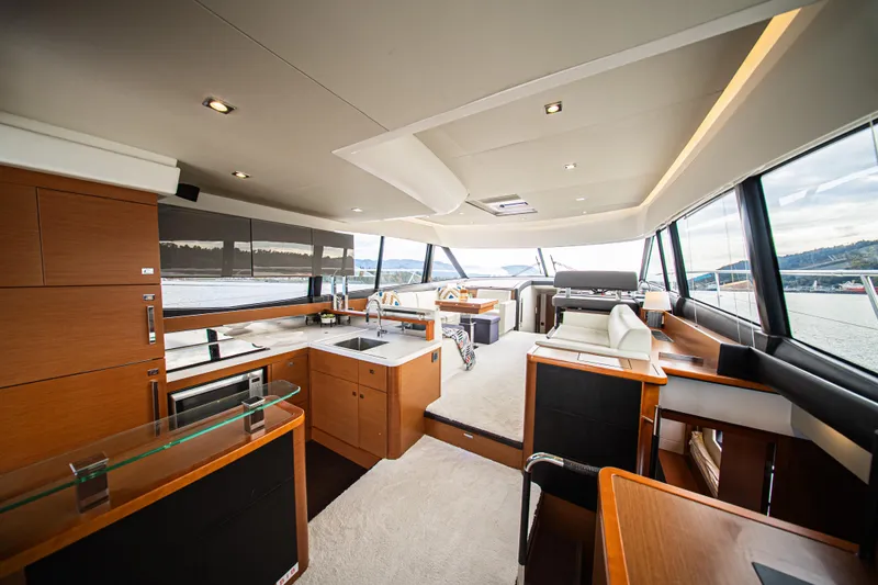 Luna Maris Yacht Photos Pics Luxurious interior of 2016 Prestige 550 Flybridge yacht with modern kitchen and seating area.