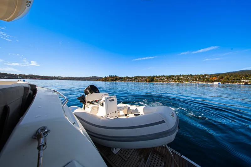 Luna Maris Yacht Photos Pics 2016 Prestige 550 Flybridge yacht with inflatable boat on serene water.