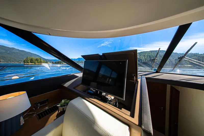 Luna Maris Yacht Photos Pics Interior view of 2016 Prestige 550 Flybridge yacht with scenic water and mountain backdrop.