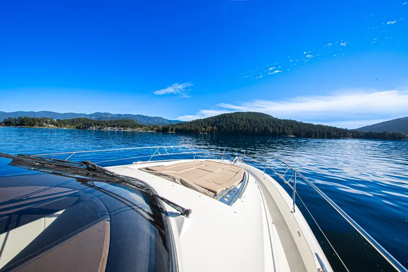 Luna Maris Yacht Photos Pics Prestige 550 Flybridge 2016 yacht cruising on a serene lake with scenic mountain views.