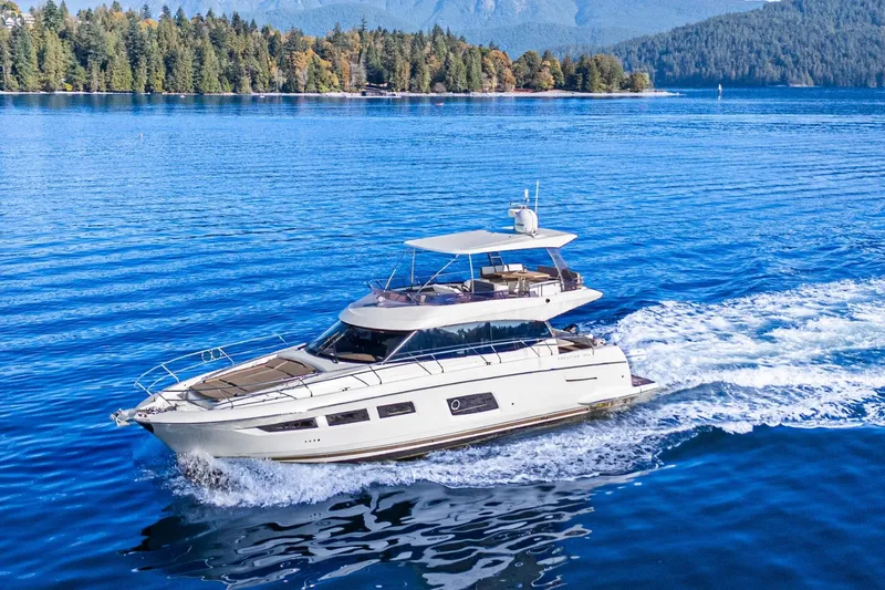 Luna Maris Yacht Photos Pics Luxury 2016 Prestige 550 yacht cruising on a serene lake with forested shoreline.